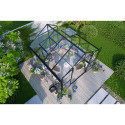 widok z góry na kwadratową szklarnie z poliwęglanu na drewnianej podstawie, wokół dużo roślin i zieleni